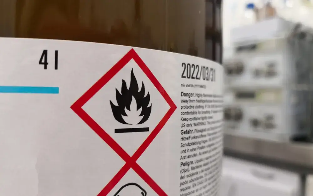 Dangerous goods drum labelled with GHS flammable and toxic pictograms
